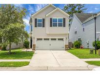 Charming two-story home with a two-car garage, manicured lawn, and classic curb appeal at 8921 Skipping Rock Ln, Summerville, SC 29485