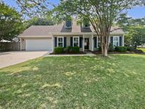 Charming home featuring a two-car garage, well-maintained lawn and mature trees in a suburban neighborhood at 932 Portabella Ln, Charleston, SC 29412