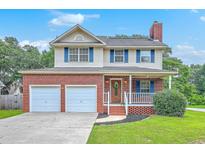 Charming two-story home with a brick facade, inviting front porch, a two-car garage and well-maintained lawn at 100 Cicero Ct, Goose Creek, SC 29445