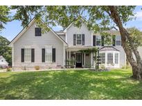 Charming two-story home with light gray siding, black shutters, manicured lawn, and inviting front porch at 100 Conset Bay Ct, Goose Creek, SC 29445