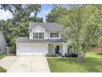 Charming two-story home with a two-car garage, a well-manicured lawn, and beautiful trees providing shade at 103 Trimley Ct, Goose Creek, SC 29445