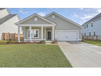 Charming single-Gathering home with a well-manicured lawn, attached garage, and inviting front porch with white pillars at 117 Oyster Tide Ave, Summerville, SC 29485