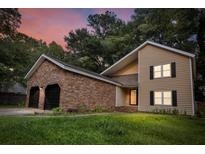 Inviting two-story home with brick accents and a spacious two-car garage under a colorful dusk sky at 119 Scottswood Dr, North Charleston, SC 29418