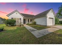 Charming one story home with white siding, manicured lawn, and concrete walkway at 129 Dovetail Cir, Summerville, SC 29483