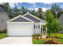 Charming one-story home features a gray exterior, attached garage, and a well-manicured lawn at 139 Sunray Ln, Summerville, SC 29486