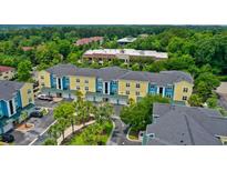 Bright apartment complex featuring blue and yellow exterior with tree lined parking and manicured landscaping at 2000 Belle Isle Ave # 204, Mount Pleasant, SC 29464
