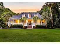 Charming home with a large front porch, dormer windows, manicured lawn and mature trees at 2040 Shell Ring Cir, Mount Pleasant, SC 29466