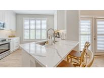Modern kitchen featuring a marble countertop island with seating and bright white cabinets at 260 Seven Farms Dr # 306, Charleston, SC 29492