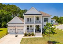 Charming two-story white home featuring a double porch, attached garage, and well-manicured front lawn at 2828 Wagner Way, Mount Pleasant, SC 29466