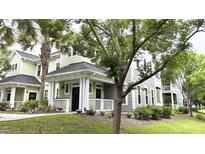 Charming condo exterior showcases green siding, covered porch, and black front door at 1225 Blakeway St # 906, Charleston, SC 29492