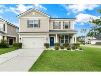Charming two-story home with a well-manicured lawn, blue front door, and an attached two-car garage at 1301 Wild Goose Trl, Summerville, SC 29483
