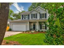 Charming two-story home with a well-manicured lawn and black shutters for a classic look at 1552 Harborsun Dr, Charleston, SC 29412