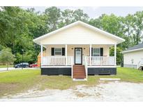 Charming cottage-style home featuring a welcoming front porch and well-maintained landscaping at 1705 Bella Terra Ln, Charleston, SC 29412