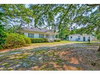 Charming home with a quaint front porch and lush greenery in a well-maintained yard at 208 State St, Walterboro, SC 29488