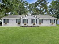 Charming single-story home with a well-manicured lawn, flower boxes and manicured garden at 2174 Eleanor Dr, North Charleston, SC 29406