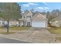 Charming two-story home with neutral siding, attached two-car garage, and a well-manicured front lawn at 240 Mayfield Dr, Goose Creek, SC 29445