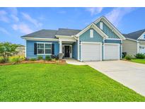 Charming home showcasing a two-car garage, manicured lawn, and beautiful blue siding at 302 Fiddleback Dr, Summerville, SC 29486