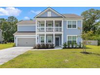 Charming two-story home with a welcoming front porch and manicured lawn on a sunny day at 4007 Oxeye, Johns Island, SC 29455