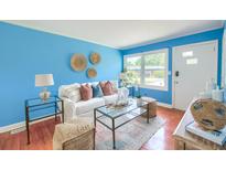 Bright living room features blue walls, stylish decor, a sofa, and glass tables, creating an inviting and modern space at 444 Clarine Dr, Goose Creek, SC 29445