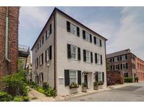 Beautiful multi-story home with black shutters, lush greenery, and classic architecture on a sunny day at 8 & 8 1/2 Elliott St # 8 & 8 1/2, Charleston, SC 29401