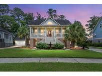 Stunning two-story home featuring a grand front porch, well-manicured lawn, and lush landscaping at 8605 Refuge Point Cir, North Charleston, SC 29420