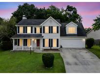 Charming two-story home with a well-manicured lawn, cozy front porch, and attached two-car garage at 103 Retriever Ln, Goose Creek, SC 29445