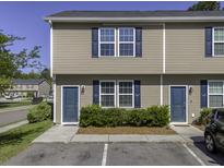 Tan townhouse exterior features blue doors, shutters and a well-maintained landscape at 1034 Lexi Ct, Ladson, SC 29456