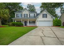 Charming two-story home with a well-manicured lawn, inviting front porch, and attached garage provides an inviting curb appeal at 106 Brandy Ct, Summerville, SC 29485