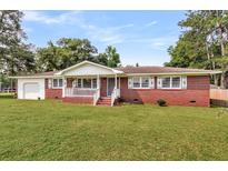 Charming brick home with a covered front porch and well-maintained lawn at 127 Roberts Rd, Summerville, SC 29483