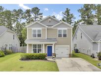 Charming two-story home with a manicured lawn, a blue front door, and attached one car garage at 1634 Eider Down Dr, Summerville, SC 29483