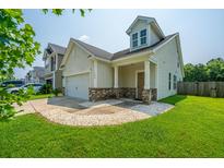 Charming two-story home features manicured lawn, attached garage, and welcoming front porch at 1689 Eider Down Dr, Summerville, SC 29483