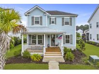 Charming light blue two-story home featuring a cozy front porch and well-manicured lawn at 1832 Agate Bay Dr, Mount Pleasant, SC 29466