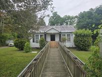 Charming single story home with a front yard and wheelchair ramp at 207 Cedar St, Saint George, SC 29477