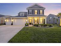 Charming two-story home with a well-manicured lawn and inviting front porch, perfect for enjoying evening sunsets at 228 Lucca Dr, Summerville, SC 29486
