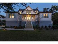 Inviting two-story home featuring a charming front porch, well-maintained lawn, and classic architectural details at 2312 Rushland Landing Rd, Johns Island, SC 29455