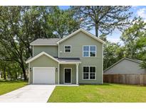 Charming two-story home with light green siding, a well-maintained lawn, and an attached one-car garage at 2960 Blackfish Rd, Johns Island, SC 29455