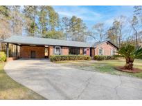 Charming brick home featuring a carport and well-maintained landscaping at 313 Runnymede Ln, Summerville, SC 29485