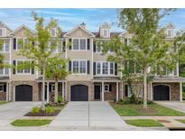 Charming townhome with brick and tan siding, black shutters, well-maintained landscaping, and a two-car garage at 3588 Bagley Dr, Mount Pleasant, SC 29466