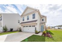 Charming two-story home with an attached garage and well-manicured lawn at 519 Purple Finch Rd, Summerville, SC 29486