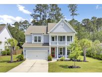 Charming two-story home featuring a welcoming front porch, well-manicured lawn, and attached two-car garage at 5541 Alpine Dr, Summerville, SC 29483