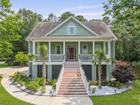 Charming two-story home featuring a wide front porch, decorative columns, and beautiful landscaping at 800 Enclave Ter, Summerville, SC 29483