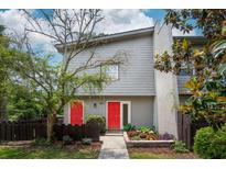 Charming two-story home boasts vibrant red doors, complemented by a lush, landscaped front yard and mature trees at 801 Ventura Pl, Mount Pleasant, SC 29464