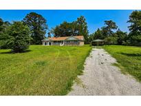 Charming brick home with a well-maintained lawn and a detached garage on a sunny day at 840 Brittle Bank Rd, Walterboro, SC 29488