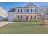 Charming two-story home featuring a well-manicured lawn and covered front porch at 100 Hunters Wood Dr, Summerville, SC 29485
