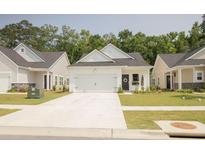 Charming one-story home featuring a pristine white exterior, a two-car garage, and a welcoming manicured front yard at 1030 Grace Field Ave, Summerville, SC 29485