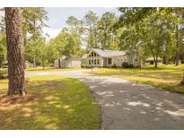 Charming single-story home boasts a well-manicured lawn, mature trees, and a private driveway at 1044 Academy Rd, Walterboro, SC 29488