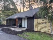 Charming single-story home featuring dark siding, a modern fence, and beautiful landscaping at 1119 Morning Glory Ct, Mount Pleasant, SC 29464