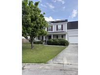 Charming two-story home featuring a well-manicured lawn, mature landscaping, and a welcoming front porch at 113 Lebsl Ct, Summerville, SC 29483