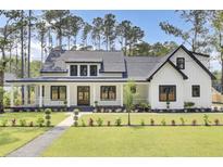 Beautiful modern farmhouse exterior with a lush green lawn and inviting front porch at 142 Argosy Dr, Summerville, SC 29483