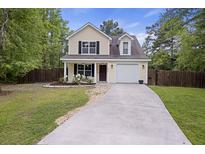Charming two-story home with well-maintained lawn, driveway and attached one car garage at 1506 Southwick Dr, Johns Island, SC 29455